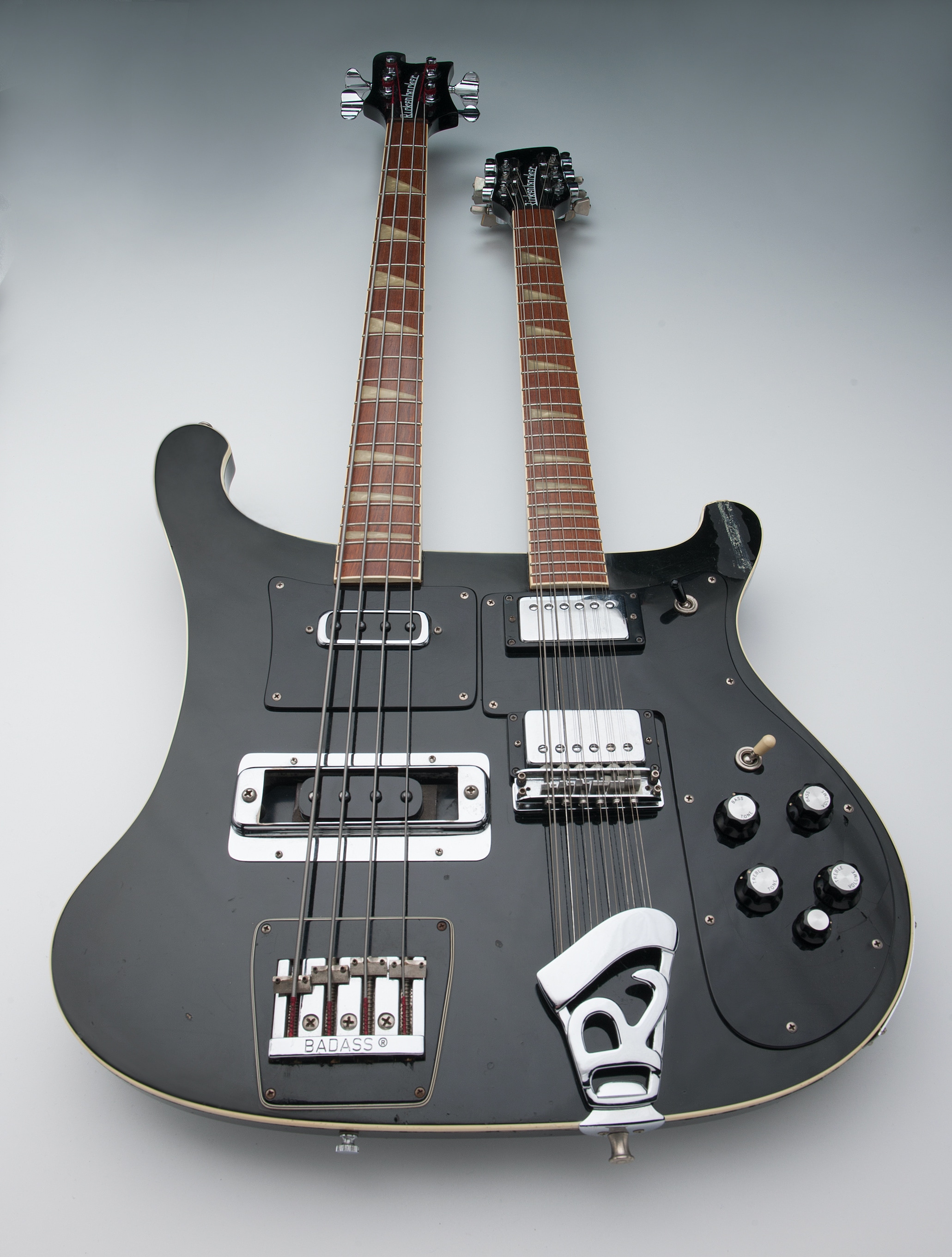 Un portrait d’une guitare électrique à double manche Rickenbacker 4080, avec un corps noir et des incrustations de perles écrasées.